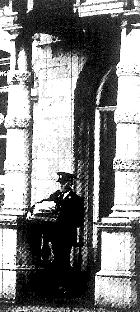 Sergeant Frank Burke helping to clear books and papers to safety from the National Bank.